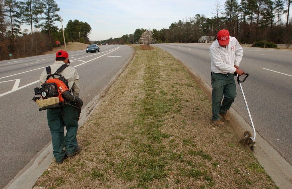 **ADVANCE FOR WEEKEND EDITIONS MARCH 19-20**  An unidentified Hispanic man, right, uses a gasoline edger to cut grass along a curb as his co-worker uses a gasoline blower to clean the opposite curb Tuesday, March 15, 2005 along N.C. State Route 54 in Durham, N.C. Manual labor for immigrants, even those who speak English, may offer more opportunity for some than seaking education. Many never enroll in school or drop out because of the pressure to earn money to help families here and back in their nativecountries. (AP Photo/Jeffrey A. Camarati)