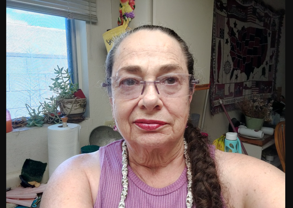 Photo shows Jodi Smith taking a selfie wearing a purple tank top.