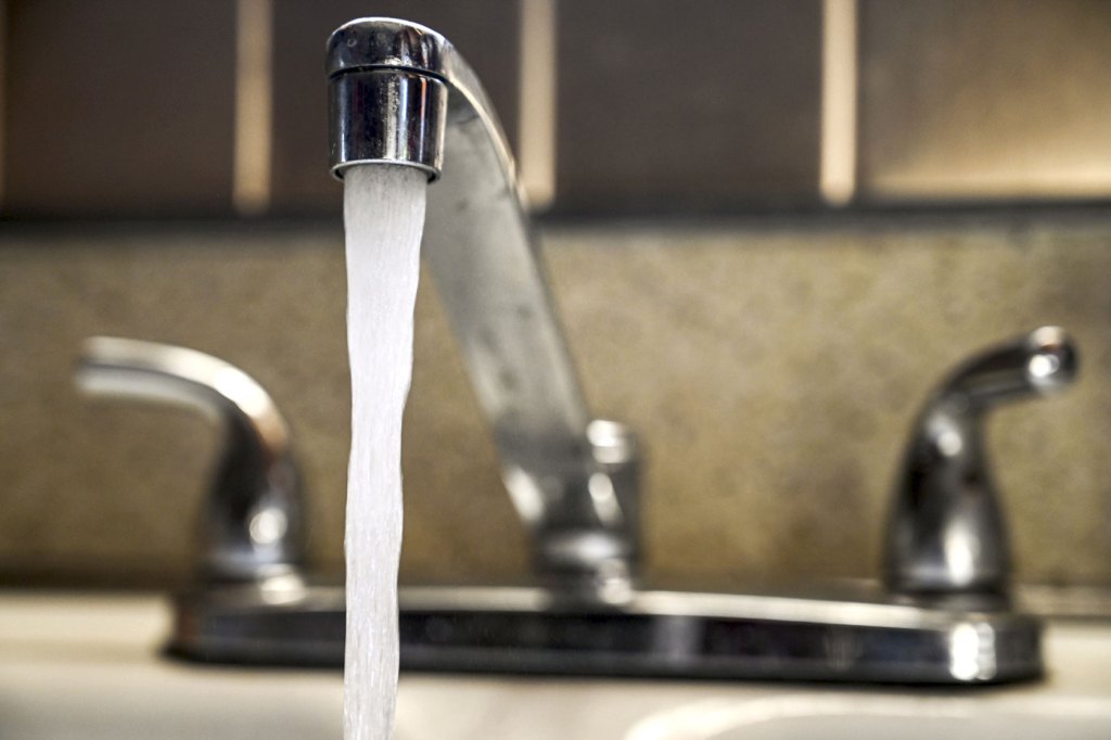 A faucet is turned on with the water running.